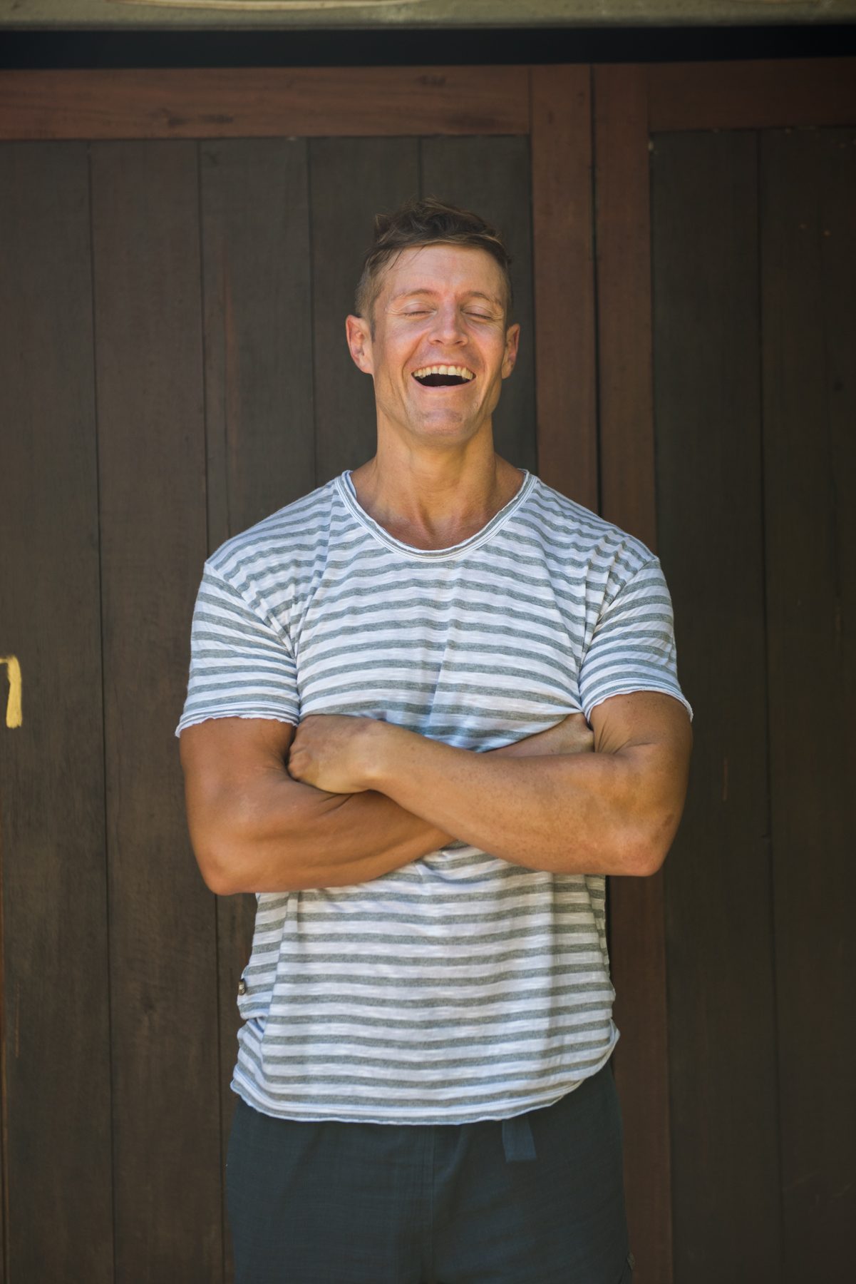 Dai at fifty, laughing with his arms crossed